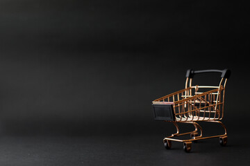 Miniature shopping chart or trolley isolated on black background with copy space © Gatot