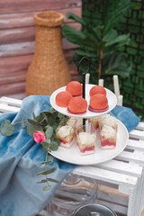 Wedding candy bar in rustic style decorated with plates, cutlery, glasses, candles and flower arrangements. Copy, empty space for text