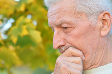 portrait of sad senior man in park