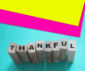 Wooden cubes with word Thankful on a light blue background. Thank you feedback concept
