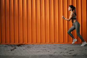 Beautiful athlete woman in sportswear. Young woman training outdoors