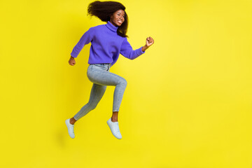Full size profile portrait of cheerful dark skin girl running look empty space isolated on yellow color background