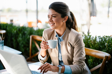 Businesswoman working in cafe. Beautiful woman with lap top having video call.