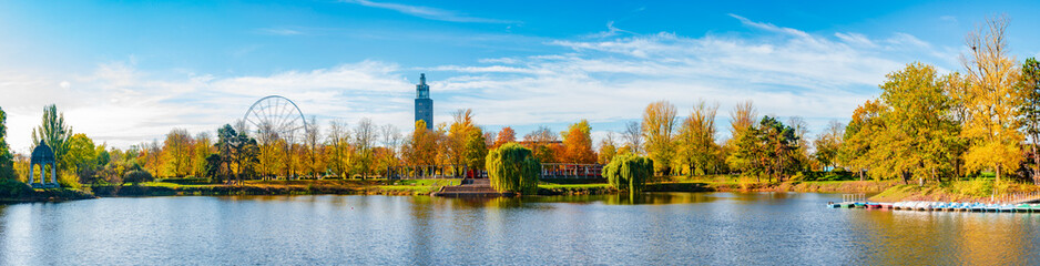 Panoramic view over city park Rotehorn and lake in Autumn colors at sunny day with blue sky, Magdeburg, Germany. - obrazy, fototapety, plakaty