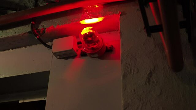 alarm system in the bunker. a red burning siren on the door. red lights are spinning in the corners of the room
