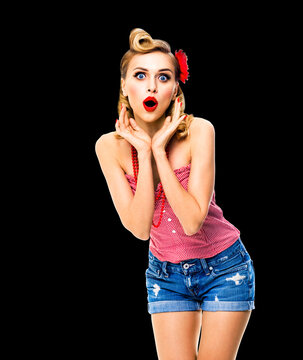 Unbelievable news! Excited surprised, very happy blondy hair woman. Pin up syle girl with open mouth and raised hands. Retro and vintage studio concept. Dark black background.