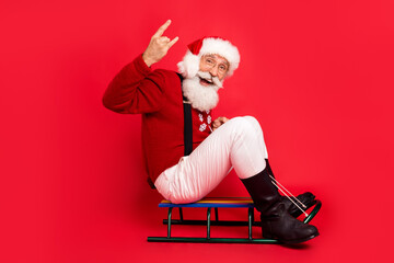 Full length body size view of nice comic cheerful Santa showing horn sign sleighing isolated over...