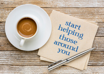 start helping those around you - inspirational advice or reminder, handwriting on a napkin with coffee, generosity and kindness concept