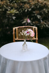 Selective focus of floral arrangement on white tablecloth.