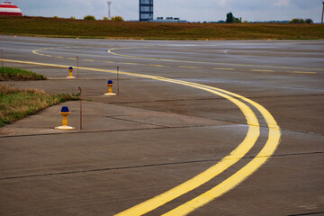 Concrete runway in airport with line marking and edge lamps