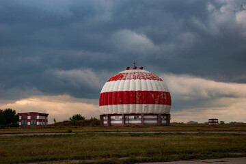 Airfield with radome or aviation radar dome painted in red and white stripes