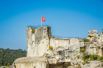 Les Baux de Provence official red flag waving in the air on a summer day