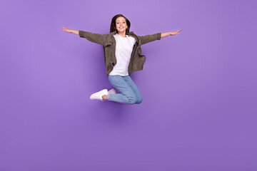 Full length body size photo smiling woman jumping up cheerful careless isolated pastel violet color background