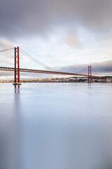 the 25 de Abril suspension bridge over Tagus river in Lisbon, Portugal at sunrise