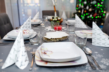 Wafer lying on the hay on the Christmas table during Christmas Eve in Poland, visible plates and glasses.