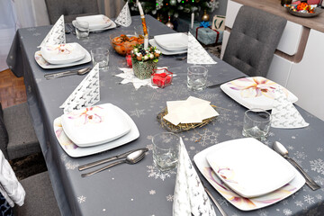 Wafer lying on the hay on the Christmas table during Christmas Eve in Poland, visible plates and glasses.