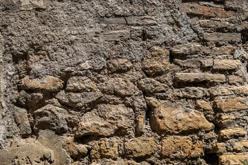 Heavily eroded, tanned colored bricks texture from the ruins of old roman walls background.