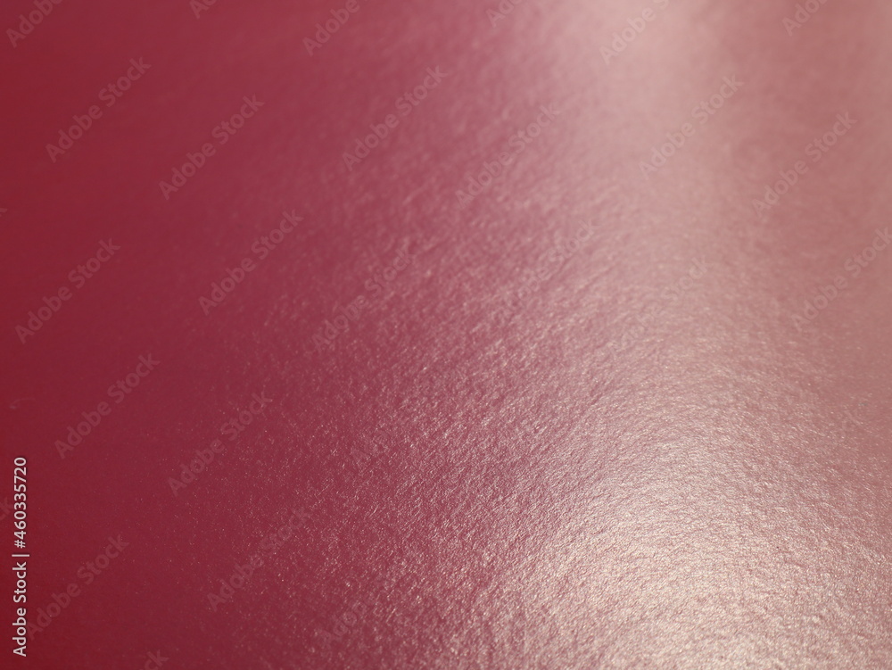 Wall mural burgundy glossy texture paper background in blurred focus with uneven lighting, dark warm blank canv