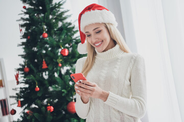 Photo portrait woman wearing white knitted sweater cap browsing internet with smartphone