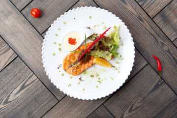 Salmon steak in a plate. On a wooden background.