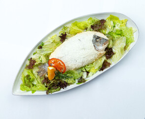 Dorado baked in salt in a plate. Isolated on white background.