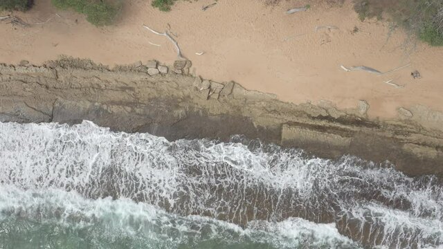 Kauai Hawaii Beach Overhead aerial POV shot, waves on rocky beach