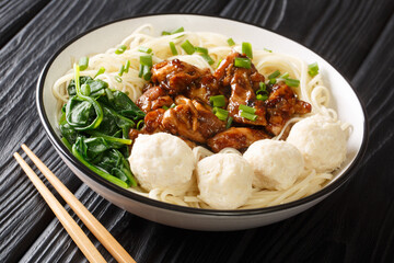 Mie ayam yellow chicken noodle and meatballs bakso closeup in the bowl on the table. Horizontal