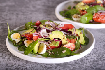 fresh salad with tomatoes avocado red onion spinach leaves and seeds 