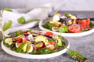 fresh salad with tomatoes avocado red onion spinach leaves and seeds 