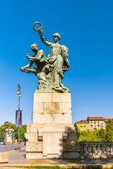 Obraz premium Turin, Italy, May 12th, 2021. Bronze statue representing the Majesty who protects the Art located near the ancient Umberto I Bridge, Corso Moncalieri side.