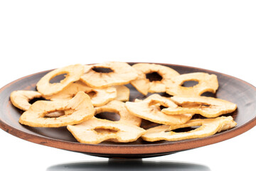 Several organic apple chips on a clay dish, close-up, isolated on white.