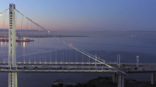 Aerial: The San Francisco Bay Bridge with morning traffic at sunrise. California, USA