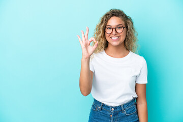 Fototapeta na wymiar Girl with curly hair isolated on blue background showing ok sign with fingers