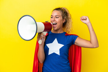 Super Hero woman isolated on yellow background shouting through a megaphone to announce something in lateral position