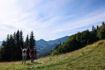 Fototapeta na wymiar Women enjoying mountain landscape on sunny day, back view. Space for text