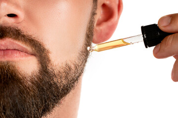 Male face and pipette with a oil for a beard growth