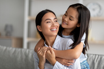 Bonding and togetherness concept. Asian mom and daughter hugging and smiling, enjoying spending time together