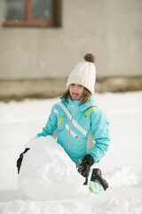 beautiful little girl sculpts snowman