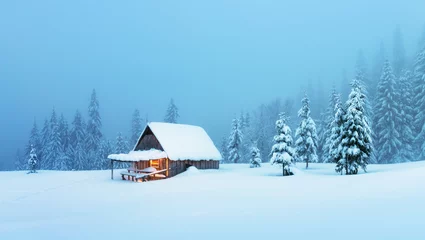 Fototapeten Fantastic winter landscape with glowing wooden cabin in snowy forest. Cozy house in Carpathian mountains. Christmas holiday concept © Ivan Kmit