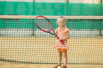 beautiful girl with Down syndrome playing tennis