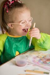 Girl with Down syndrome covered in paint when drawing