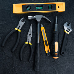 Many different tools for repair work on a black background