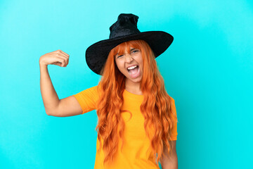 Young woman disguised as witch isolated on blue background doing strong gesture