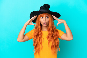 Young woman disguised as witch isolated on blue background with surprise expression