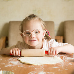 girl with down syndrome unrolls dough