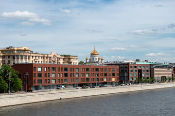 View of the dome of the Cathedral of Christ the Savior, houses on Prechistenskaya embankment and  the Moskva River in sunny morning Moscow