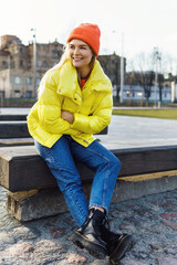 Stylish gor; wearing yellow puffer and orange knitted hat