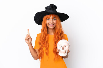 Young mixed race woman disguised as witch holding a skull isolated on white background pointing up a great idea