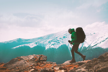 Obraz premium Amazing landscape with snowy mountains range and hiker with backpack on a foreground. Travel and adventure concept