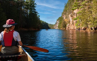 Foto op Canvas A canoe trip down the Barron River, through the Gorge  in Algonquin Park.  A female paddler looks towards another canoe and the start of the Gorge.   © Robert McAlpine